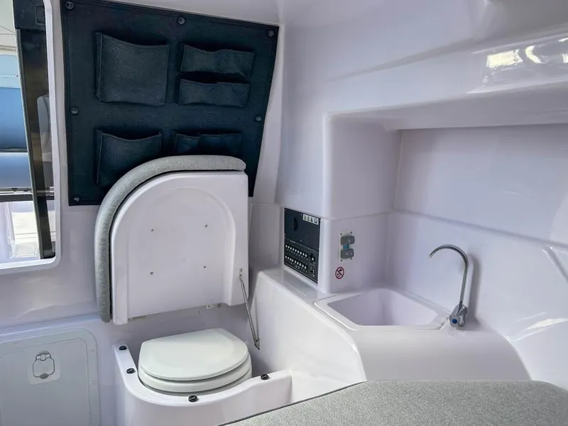 Slide: The Image of 2024 Axopar 25 Cross Top boat interior with toilet and sink. - 9