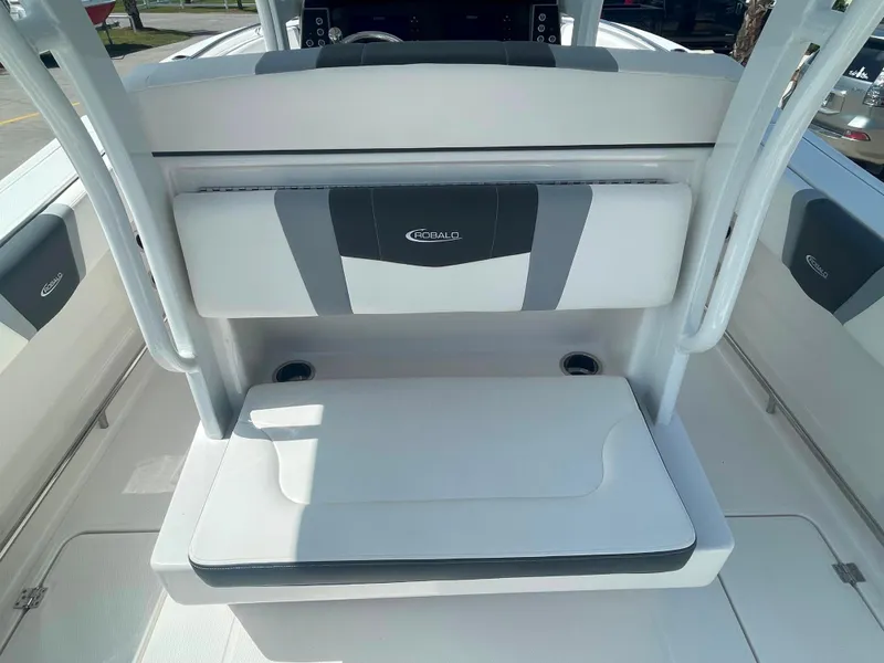 Slide: The Image of 2023 Robalo R270 boat seating area with cup holders and cushioned backrest. - 9