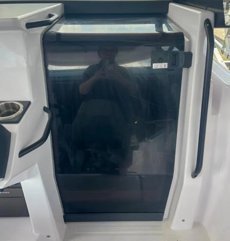 Slide: The Image of 2024 Axopar 25 Cross Top boat cabin door with sleek design and modern features. - 11