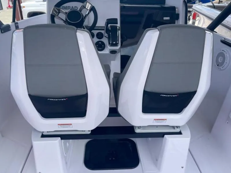 Slide: The Image of 2024 Axopar 25 Cross Top boat interior with dual seats and steering console. - 9