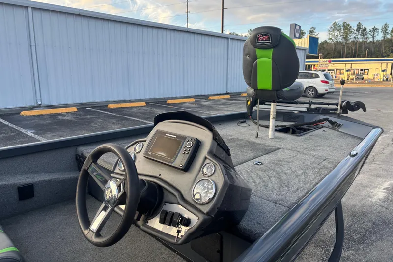 Slide: The Image of 2022 Ranger RT188 boat interior with steering wheel and control panel in parking lot. - 14