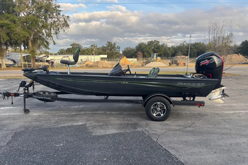 Slide: The Image of 2022 Ranger RT188 boat on trailer, parked outdoors under cloudy sky. - 6