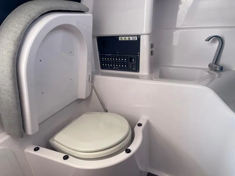 Slide: The Image of 2024 Axopar 25 Cross Top boat interior with compact bathroom and modern amenities. - 15