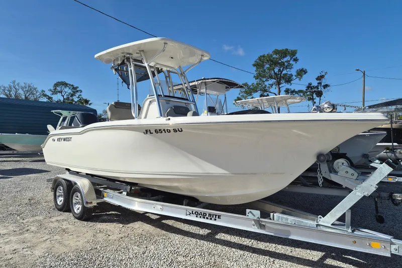 The Image of 2021 Key West 239 FS boat on trailer, parked outdoors under clear blue sky. - 1