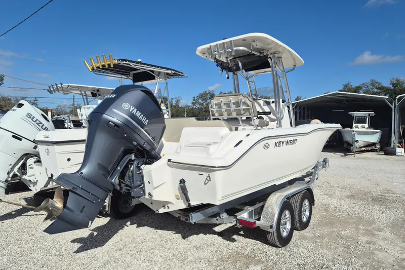 Slide: The Image of 2021 Key West 239 FS boat with Yamaha engine on trailer, parked outdoors. - 2