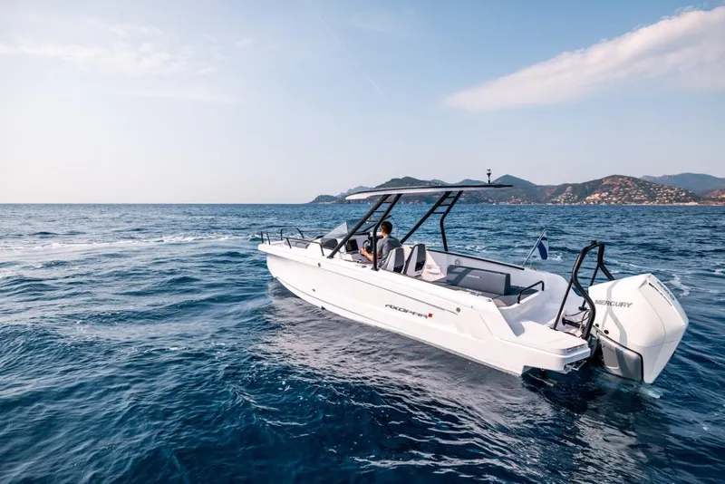 Slide: The Image of 2024 Axopar 25 Cross Top boat cruising on open sea near scenic coastline. - 11