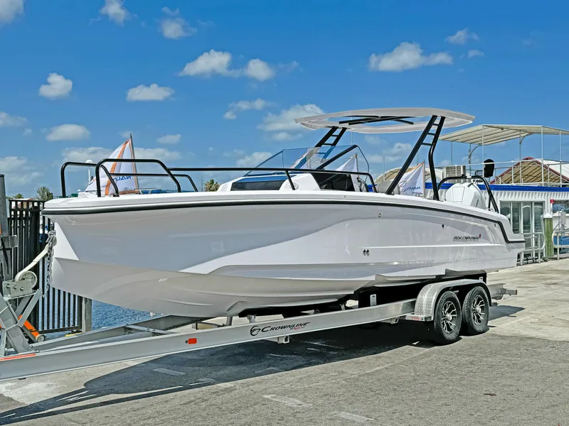 The Image of 2024 Axopar 25 Cross Top boat on trailer under clear blue sky. - 0