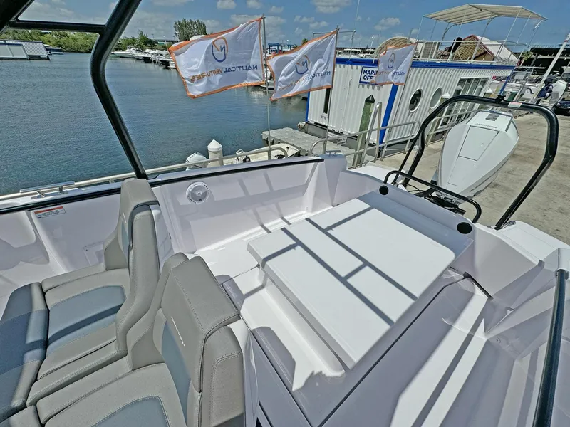 Slide: The Image of 2024 Axopar 25 Cross Top boat interior with seating, docked at marina. - 5