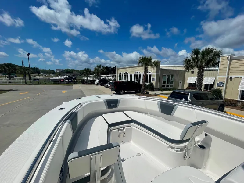 Slide: The Image of 2023 Robalo R270 boat with spacious seating, docked at a marina under a clear blue sky. - 19