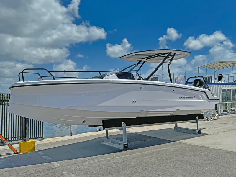 The Image of 2025 Axopar 25 Cross Top boat displayed on a stand under a blue sky. - 0