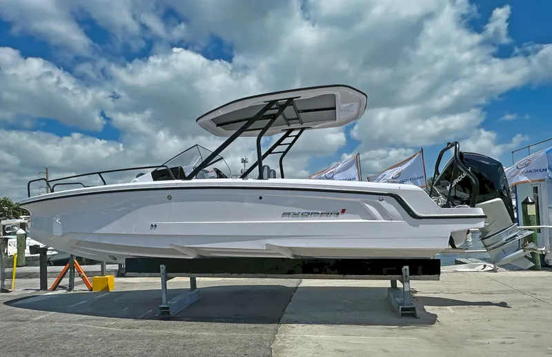 The Image of 2025 Axopar 25 Cross Top boat displayed outdoors under a cloudy sky. - 1