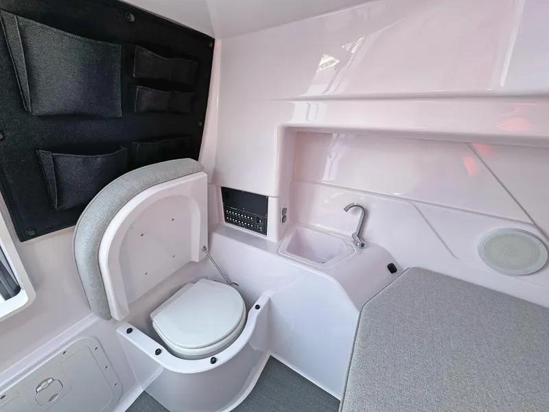 Slide: The Image of 2025 Axopar 25 Cross Top interior with toilet, sink, and storage compartments. - 10