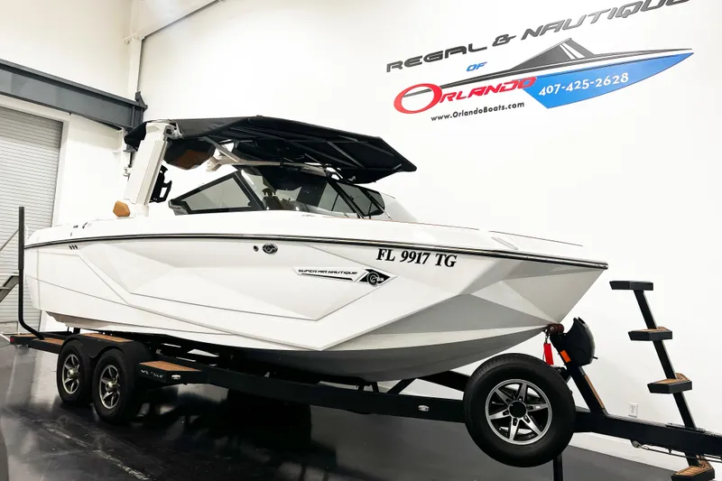 The Image of 2022 Nautique Super Air Nautique G23 boat on trailer in showroom. - 1