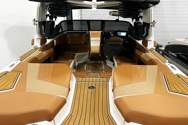 Slide: The Image of 2022 Nautique Super Air Nautique G23 interior with tan seating and modern dashboard. - 10