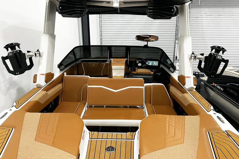 Slide: The Image of 2022 Nautique Super Air Nautique G23 interior with tan seating and advanced dashboard. - 11