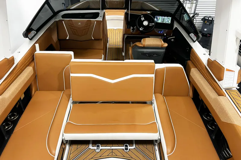 Slide: The Image of 2022 Nautique Super Air Nautique G23 interior with tan and white seating, modern dashboard. - 12
