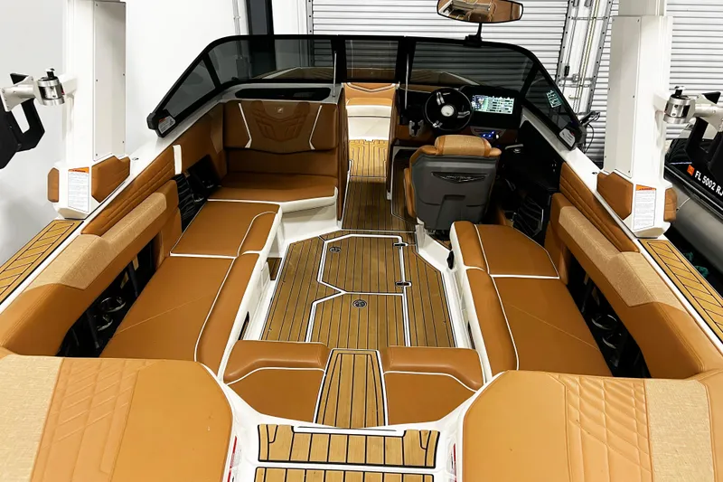 Slide: The Image of 2022 Nautique Super Air Nautique G23 interior with tan seating and sleek dashboard design. - 13