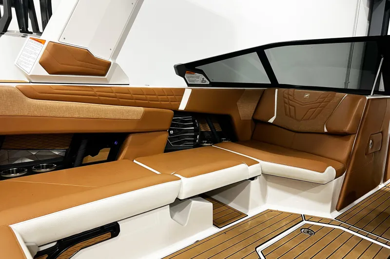 Slide: The Image of 2022 Nautique Super Air Nautique G23 interior with tan and white seating, modern design. - 14