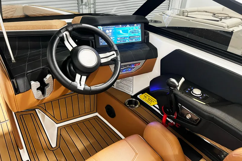 Slide: The Image of 2022 Nautique Super Air Nautique G23 boat interior with modern dashboard and steering wheel. - 16