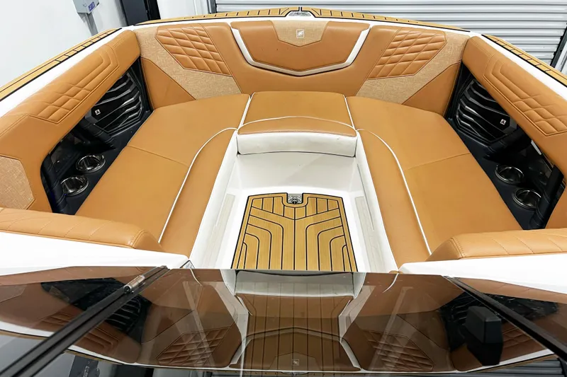Slide: The Image of 2022 Nautique Super Air Nautique G23 interior with tan leather seating and cup holders. - 17