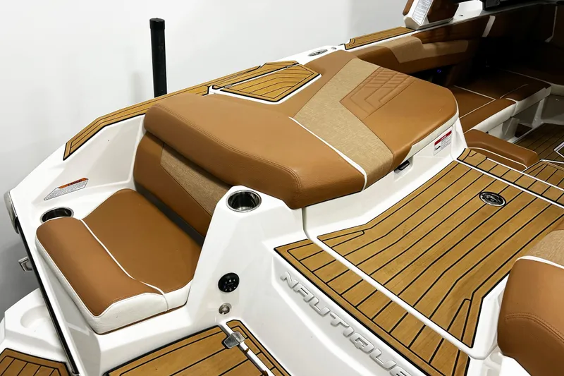 Slide: The Image of 2022 Nautique Super Air Nautique G23 boat interior with tan seating and teak flooring. - 8