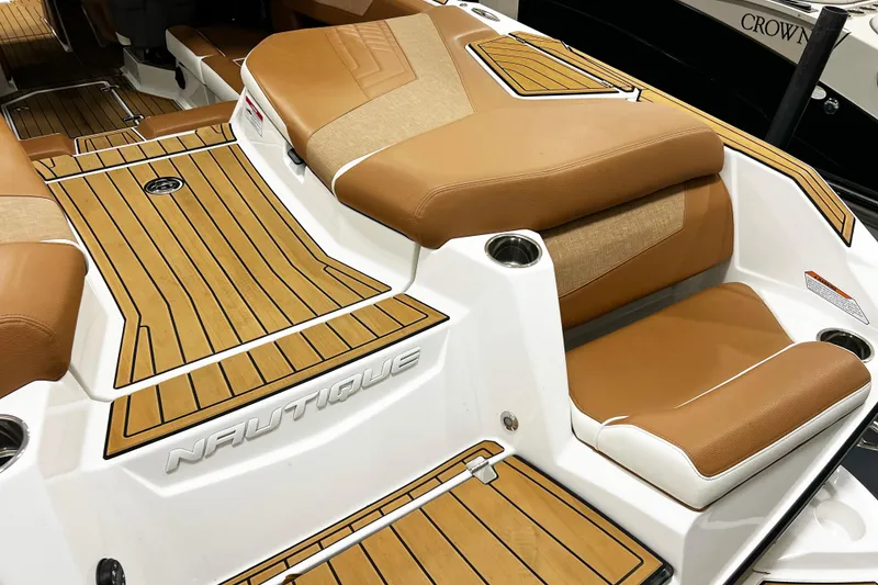 Slide: The Image of 2022 Nautique Super Air Nautique G23 boat interior with tan seating and teak flooring. - 9