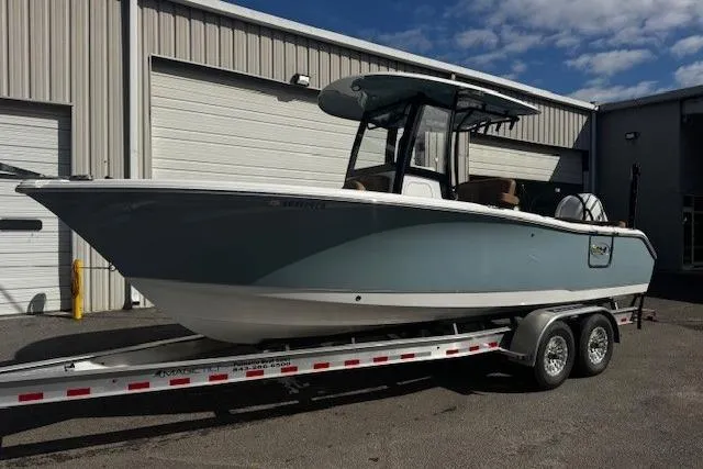The Image of 2023 Sea Hunt Ultra 255 SE boat on trailer, parked outside industrial building. - 0