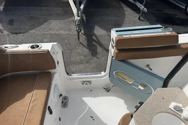 Slide: The Image of 2023 Sea Hunt Ultra 255 SE boat interior with brown seating and open door. - 15