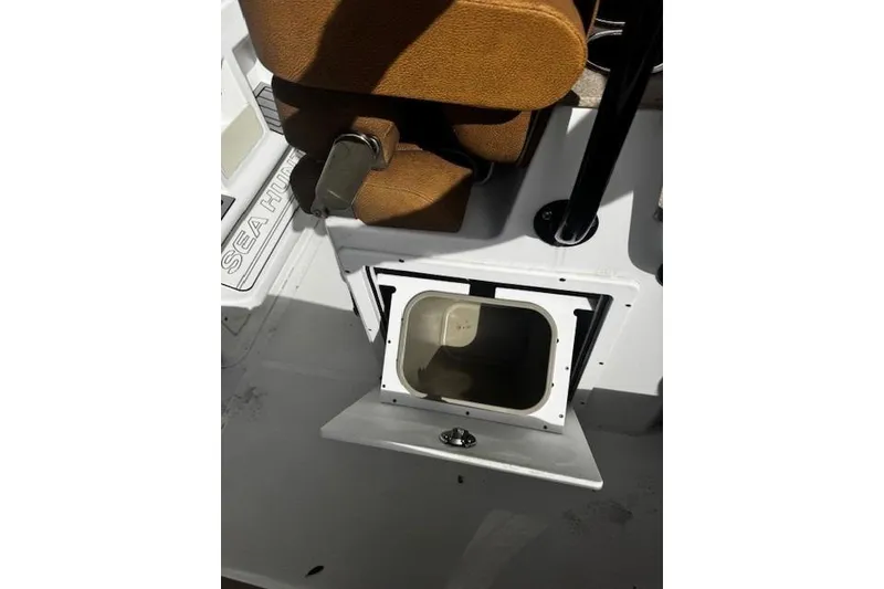 Slide: The Image of 2023 Sea Hunt Ultra 255 SE boat interior storage compartment with brown seating. - 17
