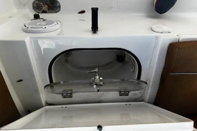 Slide: The Image of 2023 Sea Hunt Ultra 255 SE boat storage compartment with open hatch and seating area. - 19