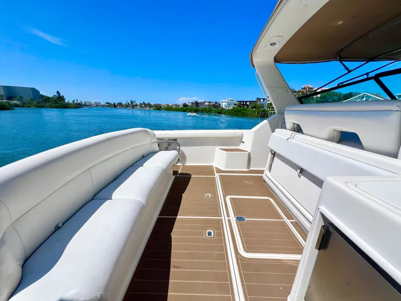 Slide: The Image of 1998 Tiara Yachts 3500 Express boat interior with white seating and scenic water view. - 11