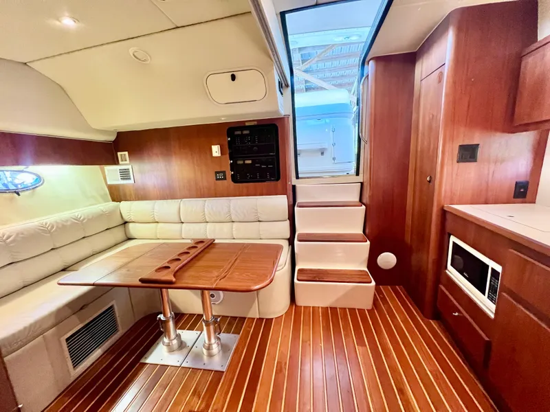 Slide: The Image of 1998 Tiara Yachts 3500 Express interior with wood finish, seating, and stairs. - 17