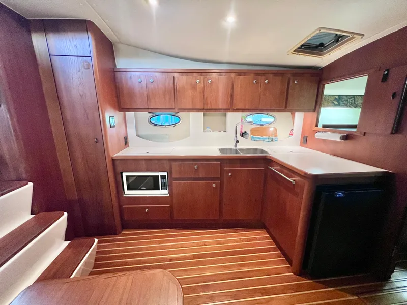 Slide: The Image of 1998 Tiara Yachts 3500 Express interior kitchen with wood cabinetry and modern appliances. - 20