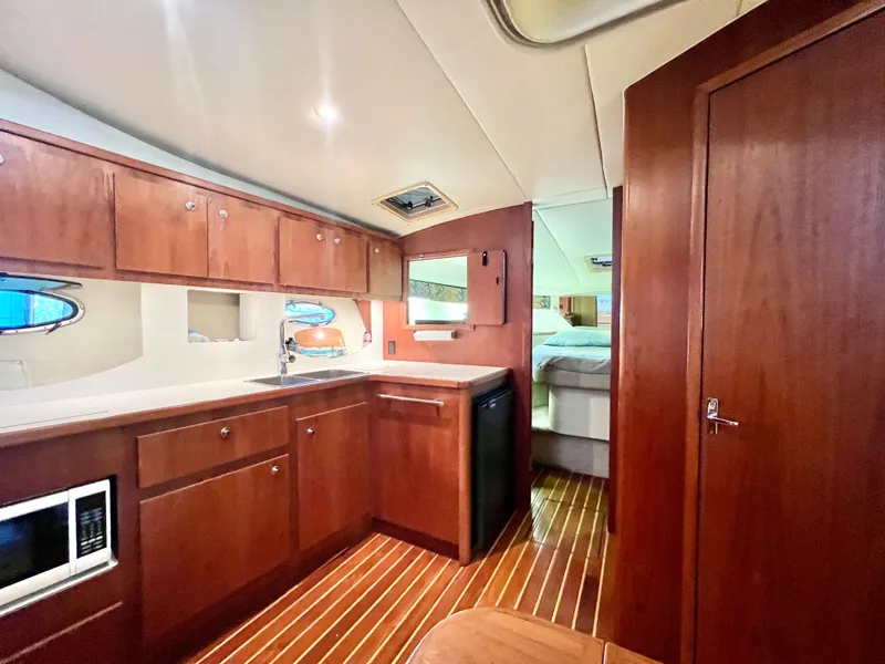 Slide: The Image of 1998 Tiara Yachts 3500 Express interior with wood cabinetry and modern amenities. - 21