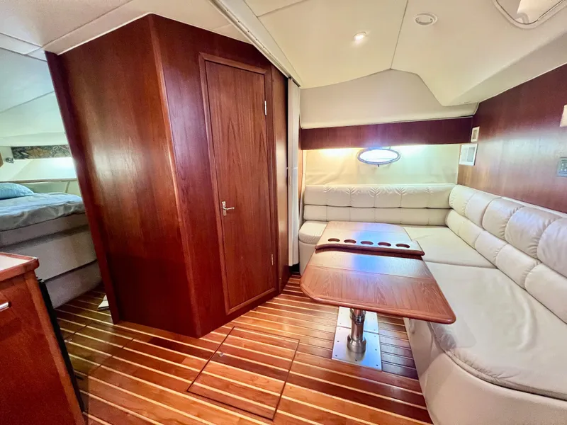 Slide: The Image of 1998 Tiara Yachts 3500 Express interior with wood paneling, leather seating, and a wooden table. - 22