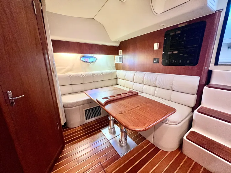 Slide: The Image of 1998 Tiara Yachts 3500 Express interior with wood accents and plush seating. - 23
