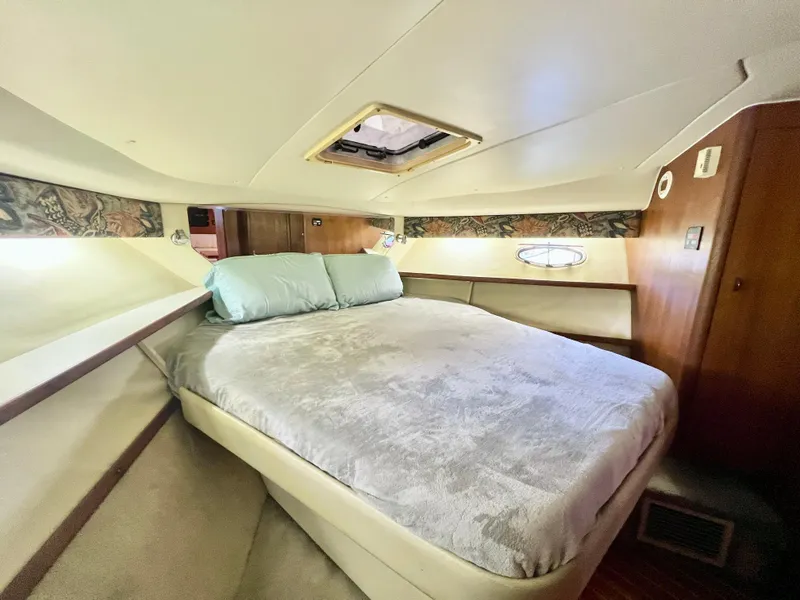 Slide: The Image of 1998 Tiara Yachts 3500 Express cabin with cozy bed and wooden interior. - 25
