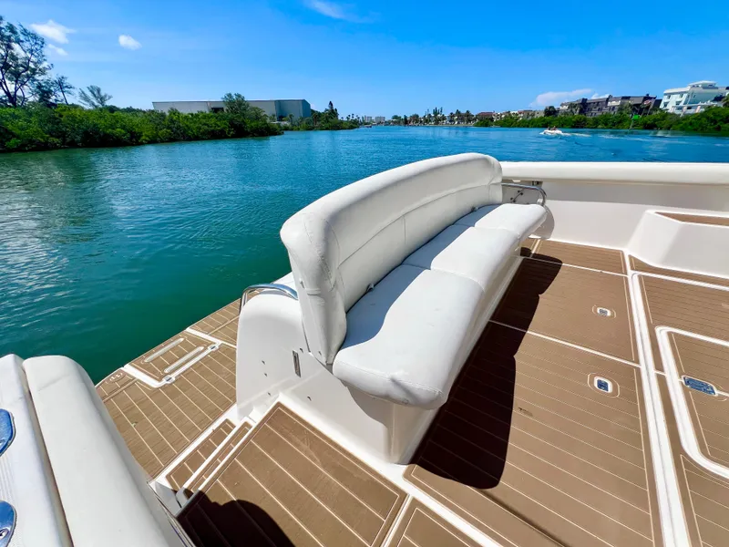 Slide: The Image of 1998 Tiara Yachts 3500 Express boat with white seating, docked on a sunny day. - 4