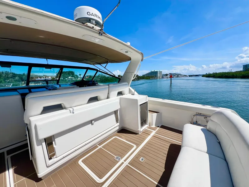 Slide: The Image of 1998 Tiara Yachts 3500 Express on water, featuring spacious deck and seating area. - 8