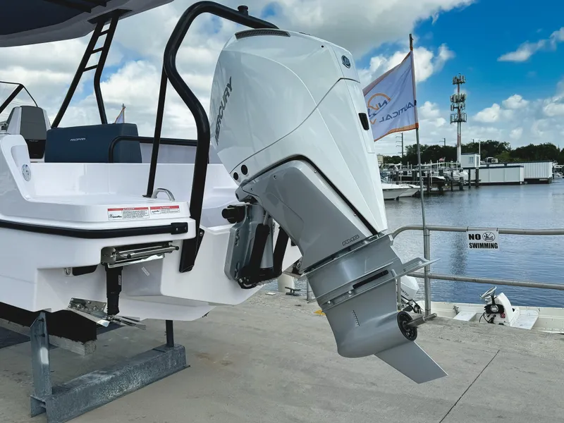 Slide: The Image of 2025 Axopar 25 Cross Top boat with powerful outboard motor at marina. - 2