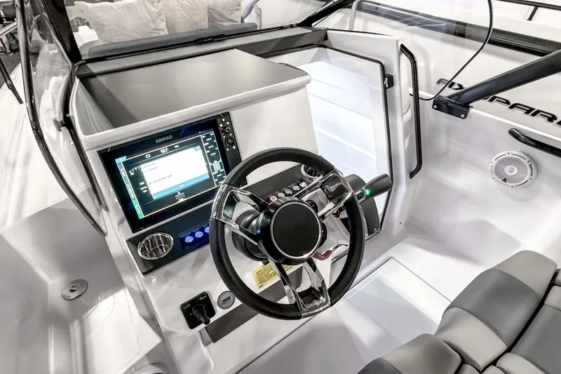 Slide: The Image of 2025 Axopar 25 Cross Top boat cockpit with modern steering and navigation system. - 9