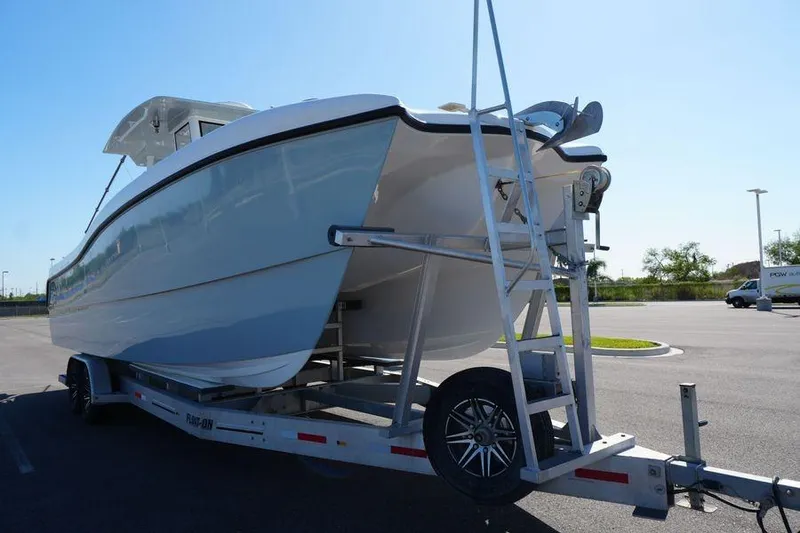Slide: The Image of 2025 Renaissance Prowler 31 boat on trailer in parking lot, side view. - 3