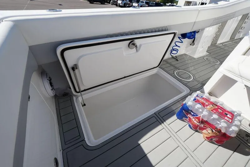 Slide: The Image of Open storage compartment on 2025 Renaissance Prowler 31 boat deck with bottled water nearby. - 9