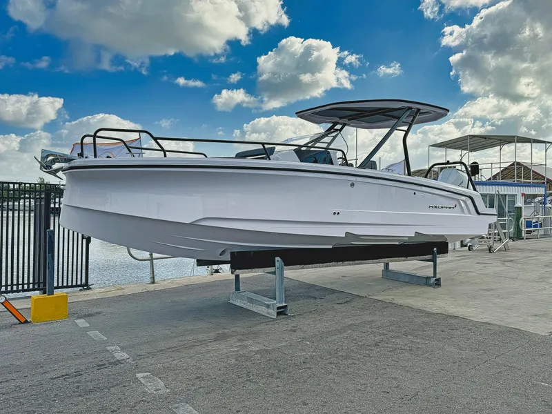 The Image of 2025 Axopar 25 Cross Top boat on display at a marina under a blue sky. - 0