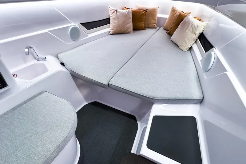 Slide: The Image of 2025 Axopar 25 Cross Top interior with cozy seating and cushions. - 10