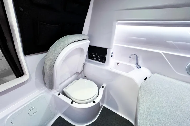 Slide: The Image of Interior of 2025 Axopar 25 Cross Top boat featuring compact bathroom amenities. - 12
