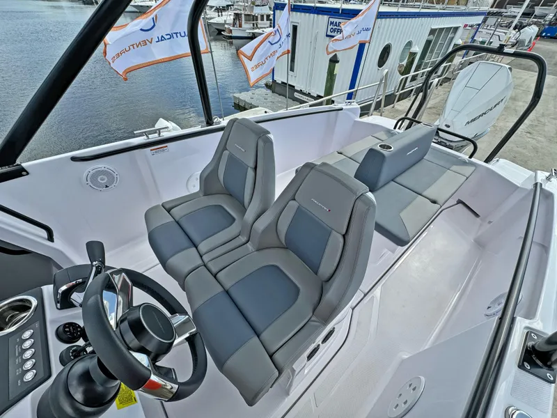 Slide: The Image of 2025 Axopar 25 Cross Top boat interior with modern seating and steering wheel. - 13