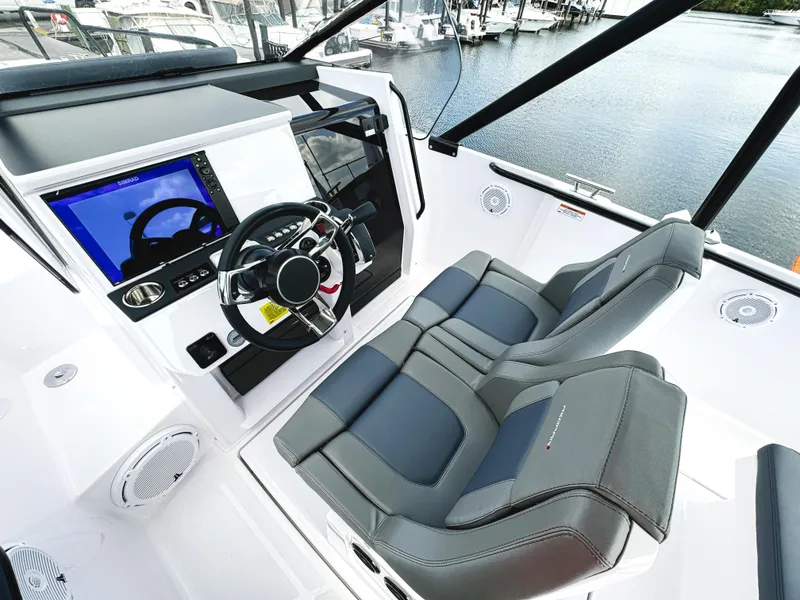 Slide: The Image of 2025 Axopar 25 Cross Top boat interior with modern steering and dual seats. - 7