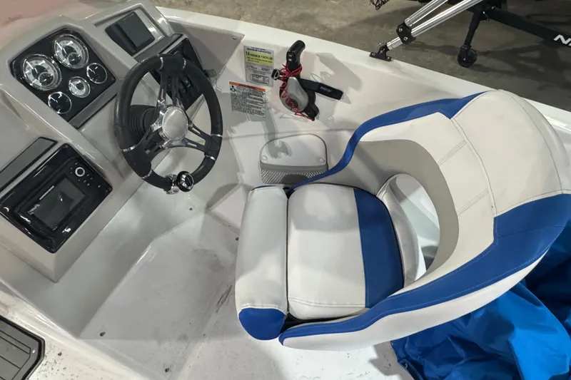 Slide: The Image of 2021 Starcraft SVX 231 OB boat cockpit with steering wheel and blue-accented captain's chair. - 6