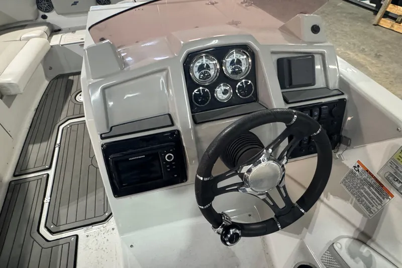 Slide: The Image of 2021 Starcraft SVX 231 OB boat dashboard with steering wheel and control gauges. - 7